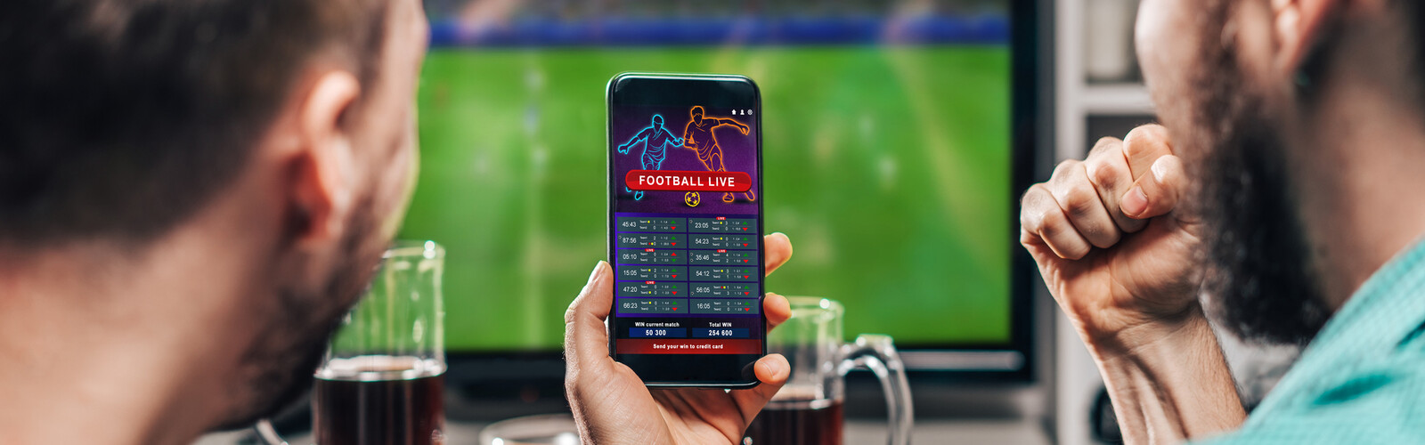 a hand holding a phone with a screen showing a football game